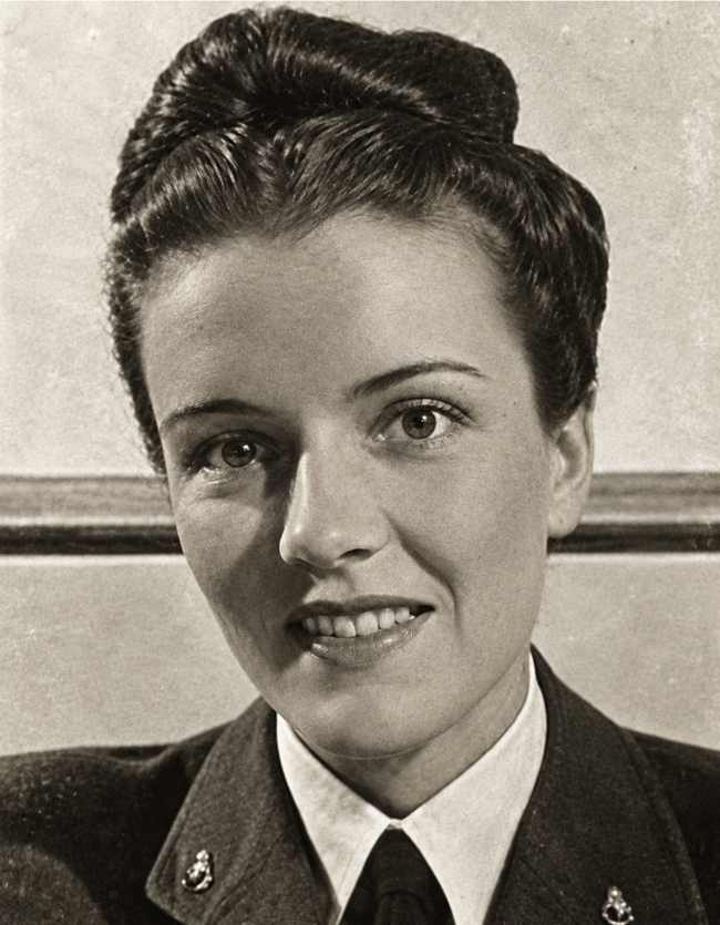 Attractive dark-haired woman, smiling, wearing British Women's Air Force uniform