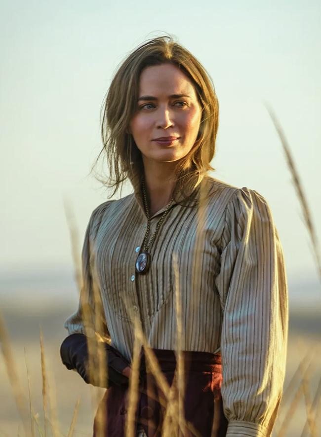 Woman in Western dress backlit by setting sun